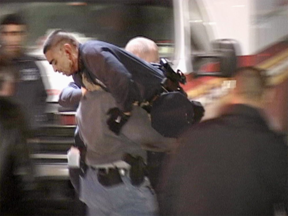 Police offer carrying another wounded police officer on his shoulder